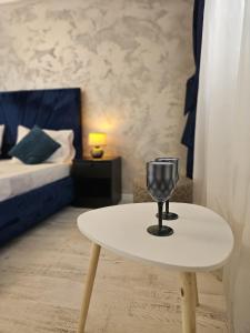 ブカレストにある89 Rooms Boutiqueの寝室に置かれたワイングラスが置かれた白いテーブル