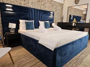 ブカレストにある89 Rooms Boutiqueの青いヘッドボード付きの大型ベッド1台が備わる客室です。