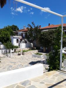 un banco blanco frente a una casa en Studios Aspasia, en Lavkos