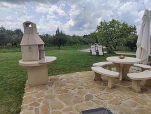 a patio with a bird feeder and a table and benches at Apartma Valce in Zgornje Škofije +3 photos