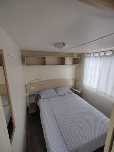 a small bedroom with a bed and a window at Apartma Valce in Zgornje Škofije