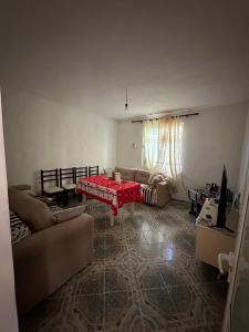 a living room with a red table and a couch at Private house surrounded by greenery in Fier