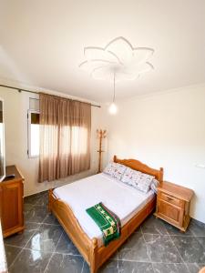 a bedroom with a bed and a chandelier at Apartamento con vistas al mar 3 in Al Hoceïma +12 photos