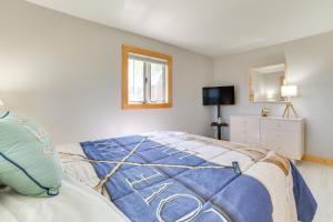 una camera da letto con un letto con una coperta blu di Houghton Lake Cottage with Patio Walk to Waterfront a Houghton Lake