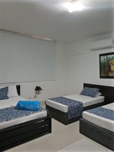 a room with three beds in a room at Hotel Medellin in Santa Marta +12 photos