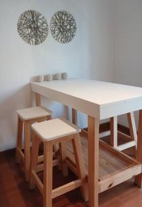 a table with two stools and a white counter top at Mein haus in Salta +12 photos