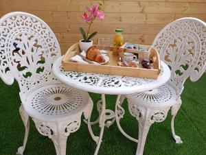 a table with two chairs with a tray of food on it at Il Rifugio delle Allodole in Leporano Marina