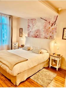 Un dormitorio con una cama y un cuadro en la pared. en Chambre Roméo ou Juliette, en Honfleur