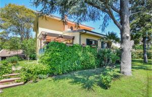a house with a tree in front of a yard at Amazing Apartment In Trecastagni in Trecastagni