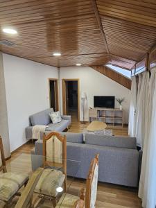 a living room with a couch and a tv at Villa Papona - Ático ,parking in Moaña +18 photos