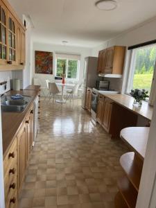 コングスビンゲルにあるStor leilighet på Finnskogen - stillhet og roの木製のキャビネットとテーブルと椅子を備えたキッチン