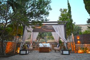 a pergola with a bed and a table and chairs at Petrino Villa Ianthe in Véssa