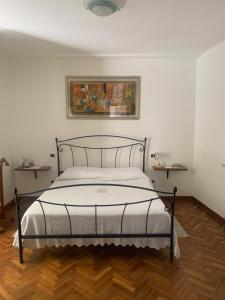 a bedroom with a bed with a picture on the wall at Il Giardino in Bastia Umbra