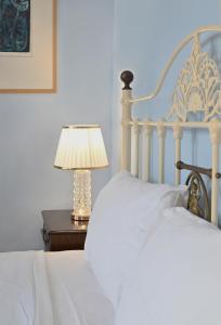 a white bed with a lamp on a table at Petrino Villa Ianthe in Véssa