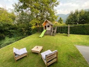 un cortile con un parco giochi, un tavolo e delle sedie di Apartma Mimi a Bohinj
