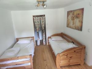 two twin beds in a room with a window at Bambusz ház in Rábapaty