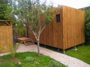 a small wooden house with a tree in a yard at La Cabane du figuier à Rambouillet in Rambouillet +6 photos