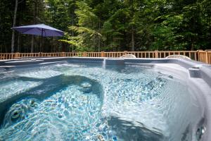 una piscina pequeña con sombrilla y sillas y sidx sidx en Chalet AuCalm, en Chertsey