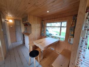 Cabaña de madera con mesa de madera y ventana en bieszczadzki holender, en Lipie