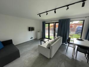 una sala de estar con un sofá y una mesa en Sol & Mar, en Międzywodzie