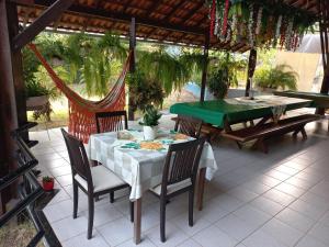 a table and chairs on a patio with a green table at Casa das Seringueiras in Alter do Chao