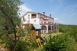 una casa con un parque infantil delante de ella en Villa Lidija, en Labin