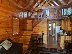 a log cabin with a kitchen and a dining room at Cabins of Mackinac & Lodge in Mackinaw City