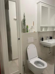 a white bathroom with a toilet and a sink at Apartment De Frata in Frata