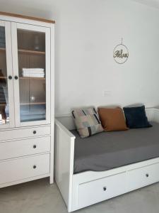 a white bedroom with a bed and a dresser at Apartment De Frata in Frata
