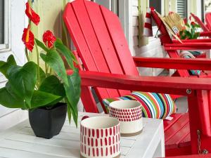 ein roter Schaukelstuhl und eine Pflanze auf einem Tisch in der Unterkunft SolMate Free Golf Cart & Pool Heat Deals in Destin