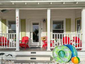 ein Haus mit roten Stühlen und einer Veranda mit in der Unterkunft SolMate Free Golf Cart & Pool Heat Deals in Destin + 53 Fotos