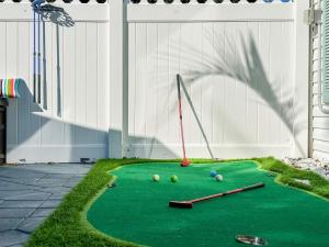 ein Minigolfplatz mit Bällen und Schlägern auf einem Grün in der Unterkunft SolMate Free Golf Cart & Pool Heat Deals in Destin
