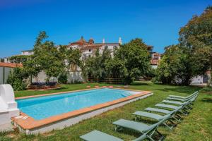 a swimming pool with lawn chairs and a building at Casa Magnolia in Galaroza