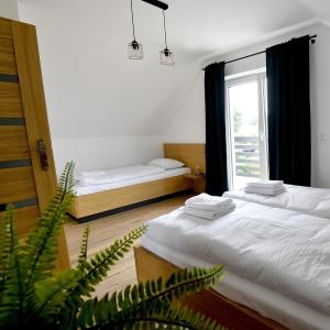 twee bedden in een kamer met een raam bij Domki na Krótkiej in Spytkowice