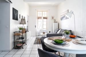 un salon blanc avec une table et des chaises dans l'établissement Le Temps d'Eugène Centre historique, à Narbonne