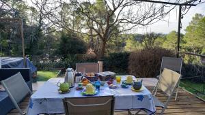 a table with a blue table cloth with food on it at La pinède de Manon Chambre et table d'hôtes in Barjols +12 photos