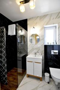 een badkamer met een witte wastafel en een toilet bij Domki na Krótkiej in Spytkowice