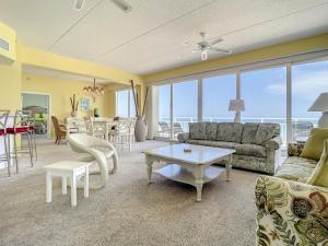 a living room with a couch and a table at Penthouse Condo with wrap around views of the ocean - SR802 in Edgewater