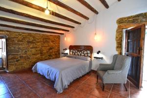 a bedroom with a bed and a stone wall at Casa Rural en la Montaña Mas de Tenesa in Benasal