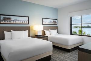 a hotel room with two beds and a window at Hyatt House Naples 5th Avenue in Naples