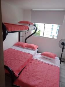 two bunk beds in a room with a window at Espectacular Apartamento Ricaurte Girardot in Ricaurte