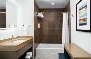 a bathroom with a tub and a sink and a shower at Hyatt House Naples 5th Avenue in Naples
