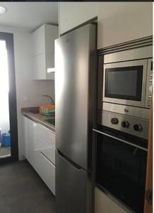 a kitchen with a stainless steel refrigerator and microwave at Apartamento El Ancla in Almería