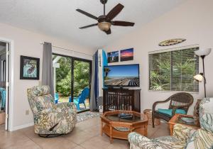a living room with chairs and a ceiling fan at Quaint 2 bedroom 2 bath villa Walking distance to the car free beach. S4358 in Edgewater