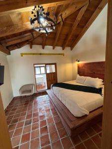 a bedroom with a large bed and a chandelier at Casa 23 San Cristóbal in San Cristóbal de Las Casas +16 photos