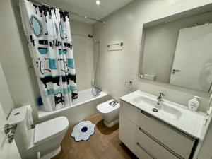 un bagno con lavandino, WC e specchio di Céntrico Piso de 2 habitaciones a Saragozza