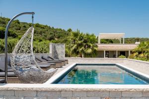 een zwembad met een schommel en een huis bij Aqua Sea Relais, Luxury Apartment & Pool in Vieste