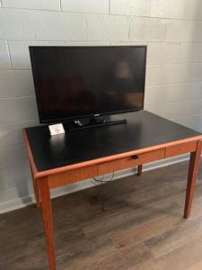 a television sitting on top of a wooden table at Paradise Suites - Newport News & Jefferson Ave in Newport News