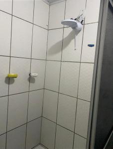 a white tiled bathroom with a sink and a shower at Casa in Garanhuns