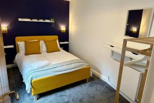 a small bedroom with a yellow bed with yellow pillows at Clock Tower Apartments 1 in Morecambe